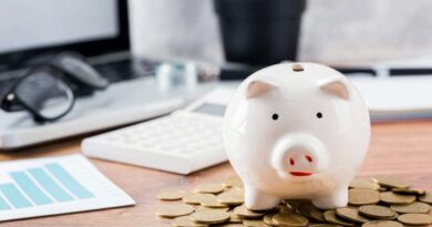 Foto de um cofrinho de porco com moedas em volta, simbolizando a diferença entre cooperativa de crédito e banco.