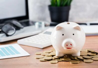 Foto de um cofrinho de porco com moedas em volta, simbolizando a diferença entre cooperativa de crédito e banco.