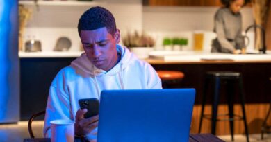 Mulher trabalhando com laptop sobre um gramado, simbolizando o visto de nômade digital para a Espanha.