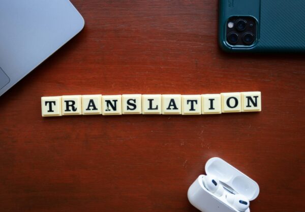 Balança da justiça sobre livros com tradutor público digitando ao fundo